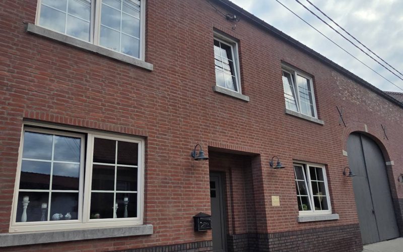 Overzicht van een rode bakstenen woning met vernieuwd voegwerk.